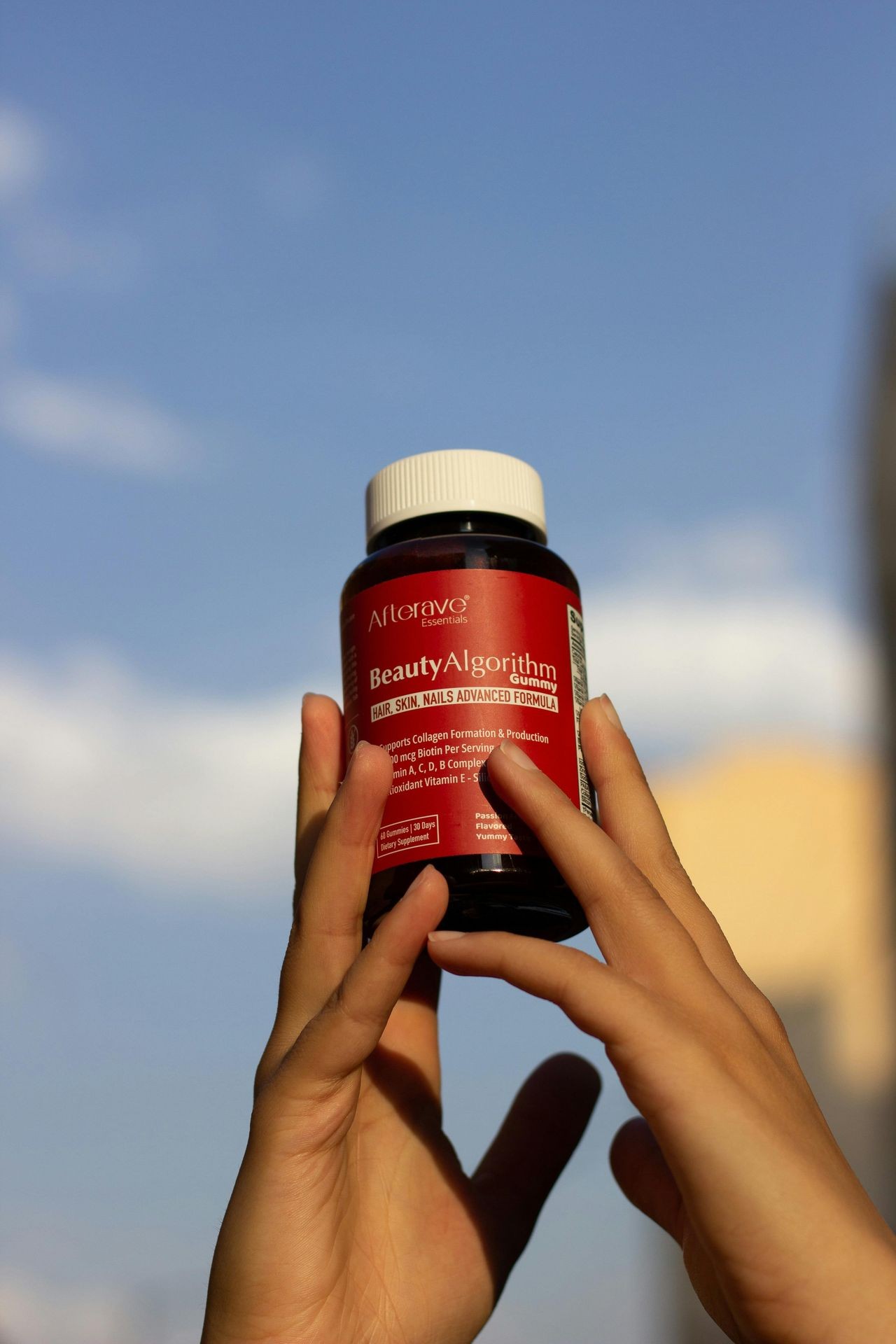 Person holding up a multivitamin tub