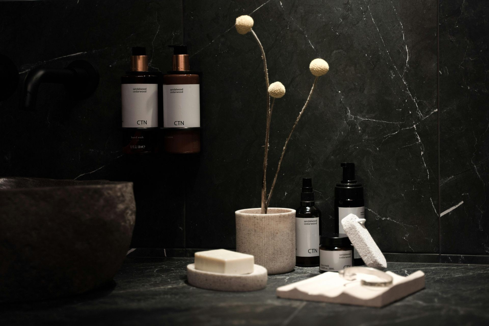 Skincare products on a black marble shelf