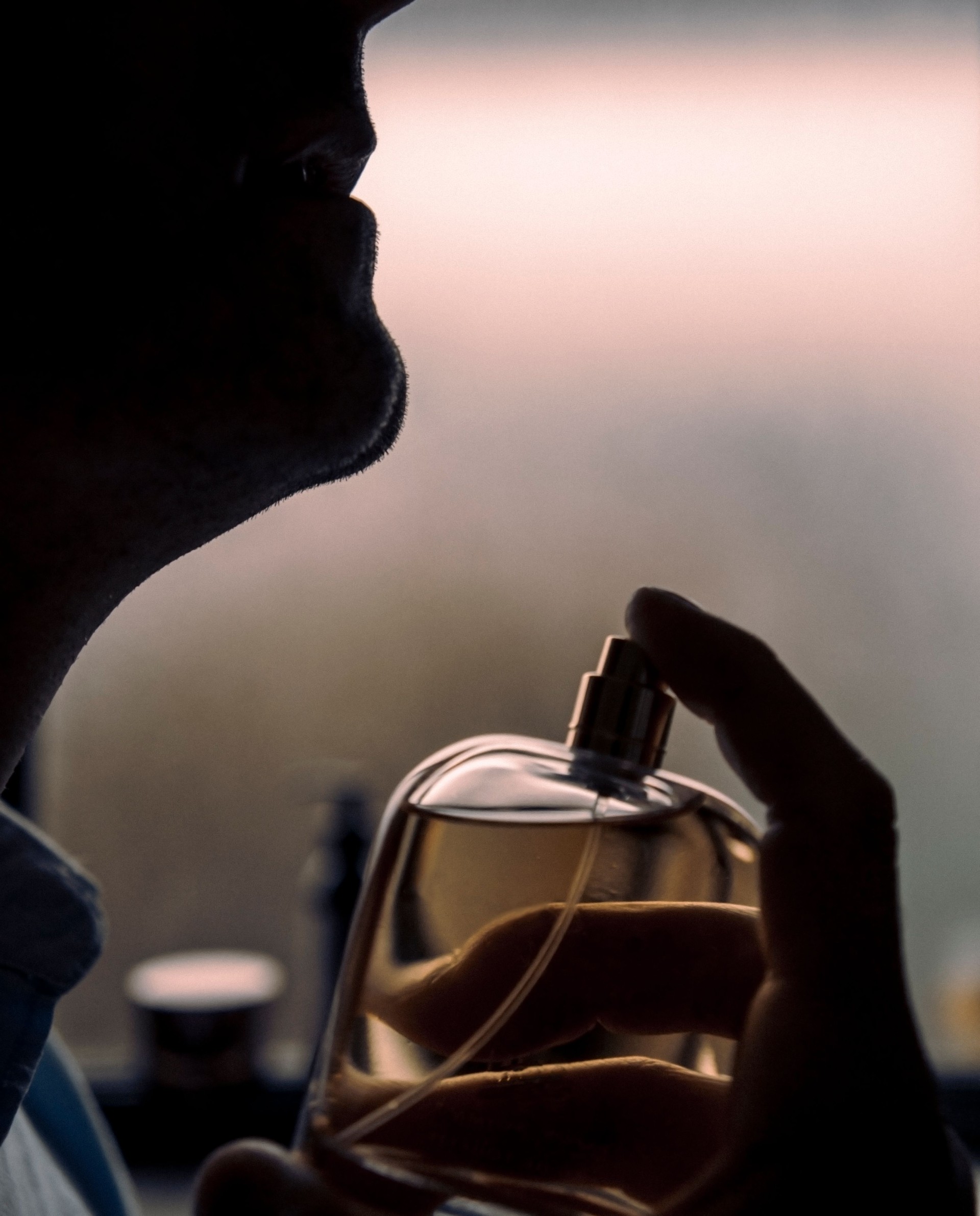 Man applying cologne eau de toilette on neck