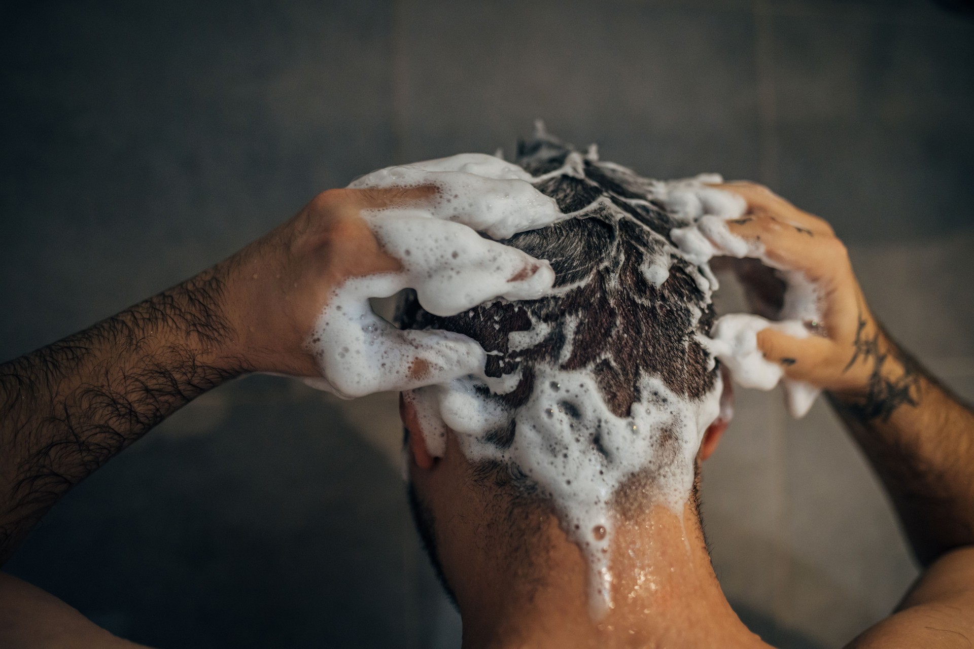 Handsome man washing hair